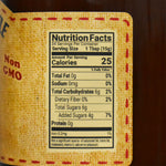 Nutrition facts label on a dutch kettle peach butter product with a yellow fabric texture.