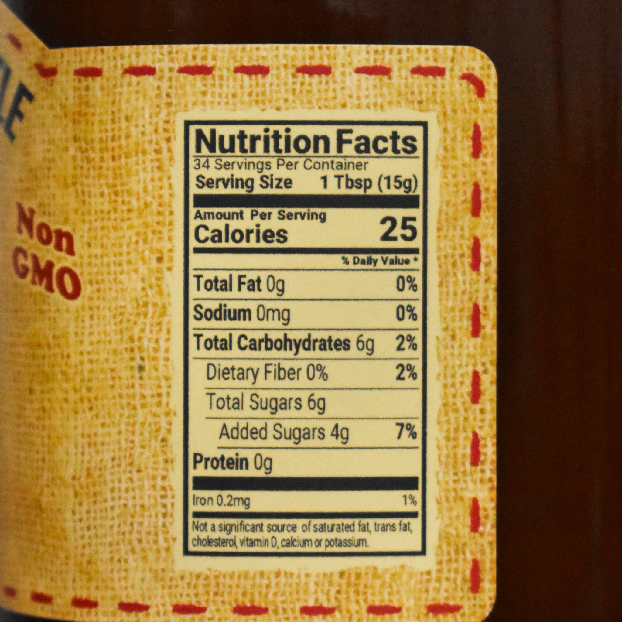 Nutrition facts label on a dutch kettle peach butter product with a yellow fabric texture.