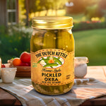 The Dutch Kettle Amish Homestyle Pickled Okra on a southern table outside in front of a yard and garden. 