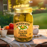 The Dutch Kettle Amish Homestyle Pickled Okra on a southern table outside in front of a yard and garden. 