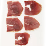Slices of Suncrest Farms country ham on a white background.