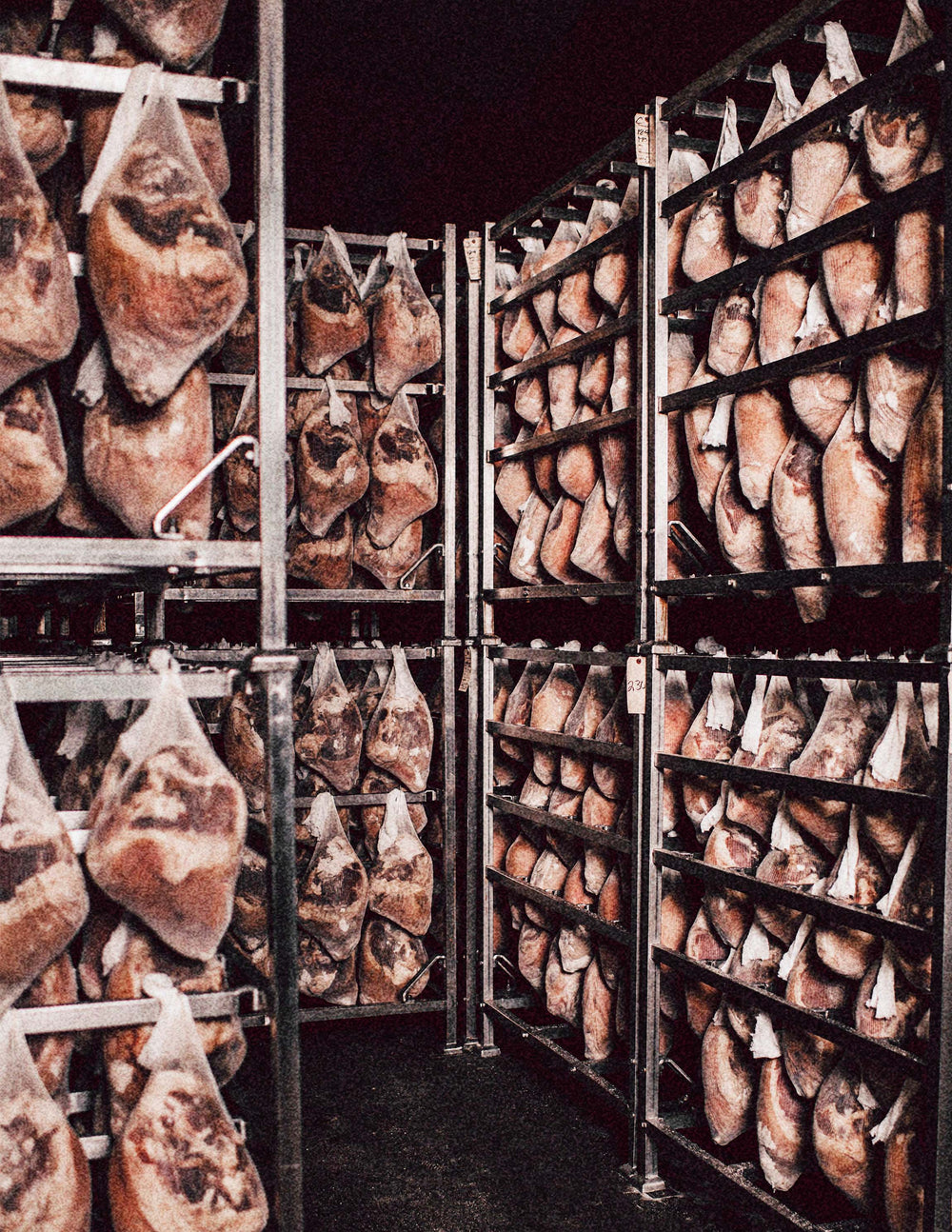 Hanging cured Suncrest country ham in a storage room.