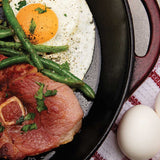 Skillet with country ham, green beans, and an egg for breakfast meal.