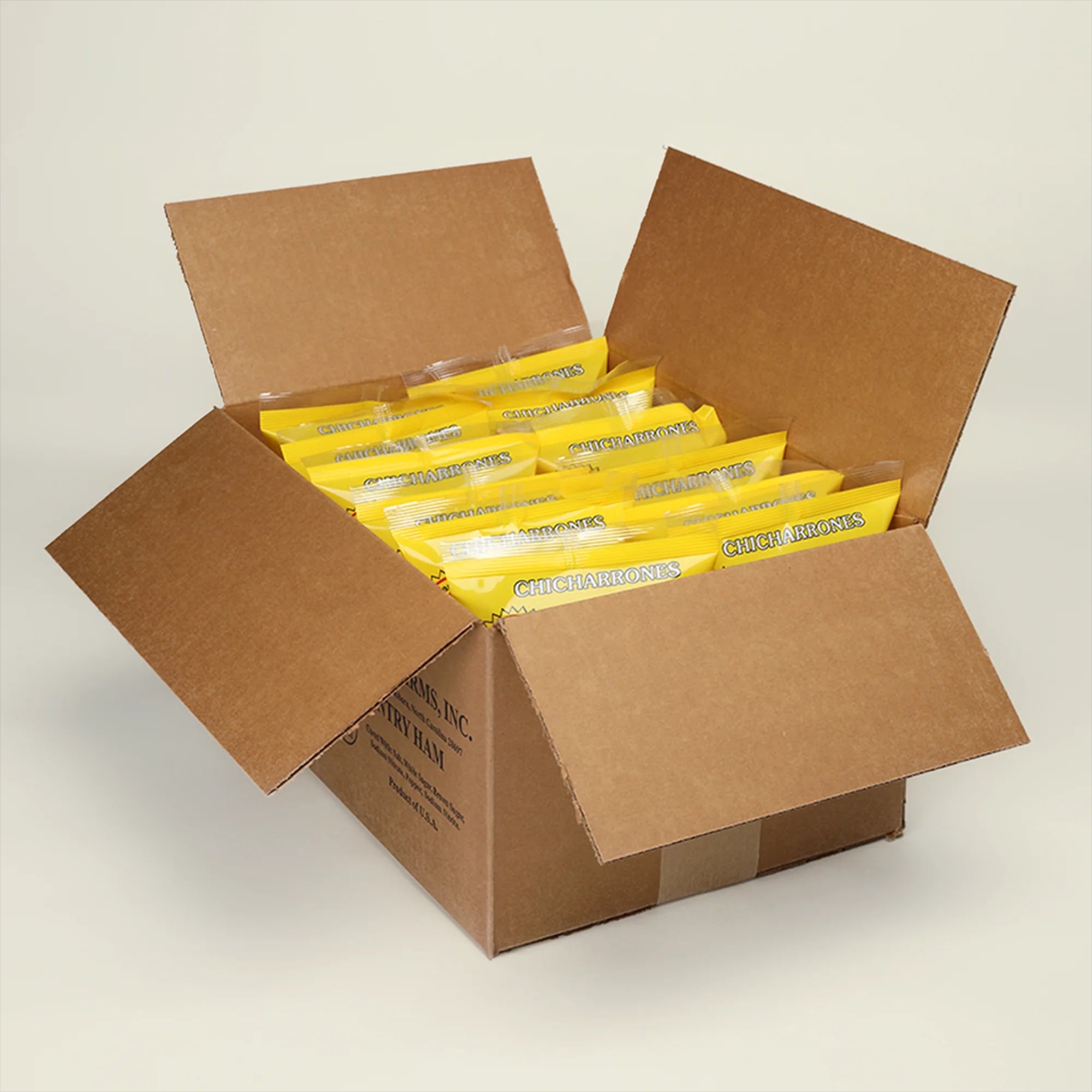 Open cardboard box with 8 packages of Suncrest Farms original pork skins inside on a light gray background.
