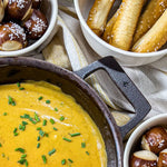 Stargazer cast iron skillet with beer cheese and pretzel bites on table. 