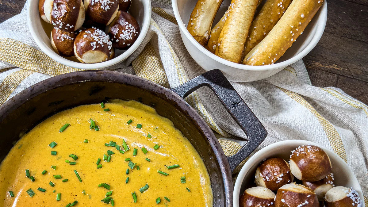Stargazer cast iron skillet with beer cheese and pretzel bites on table. 
