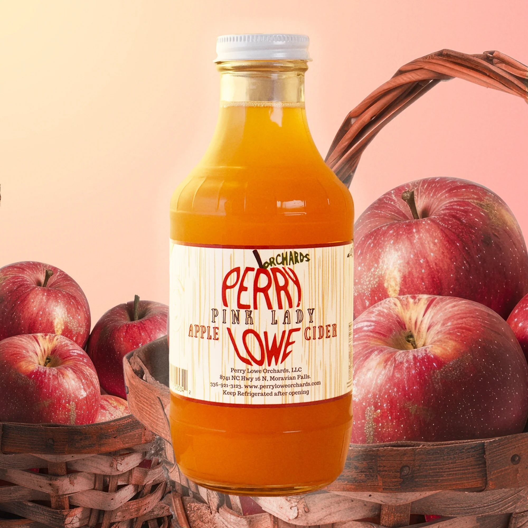 Perry Lowe orchards pink lady apple cider in a jar, apples in picnic baskets in backrgound.
